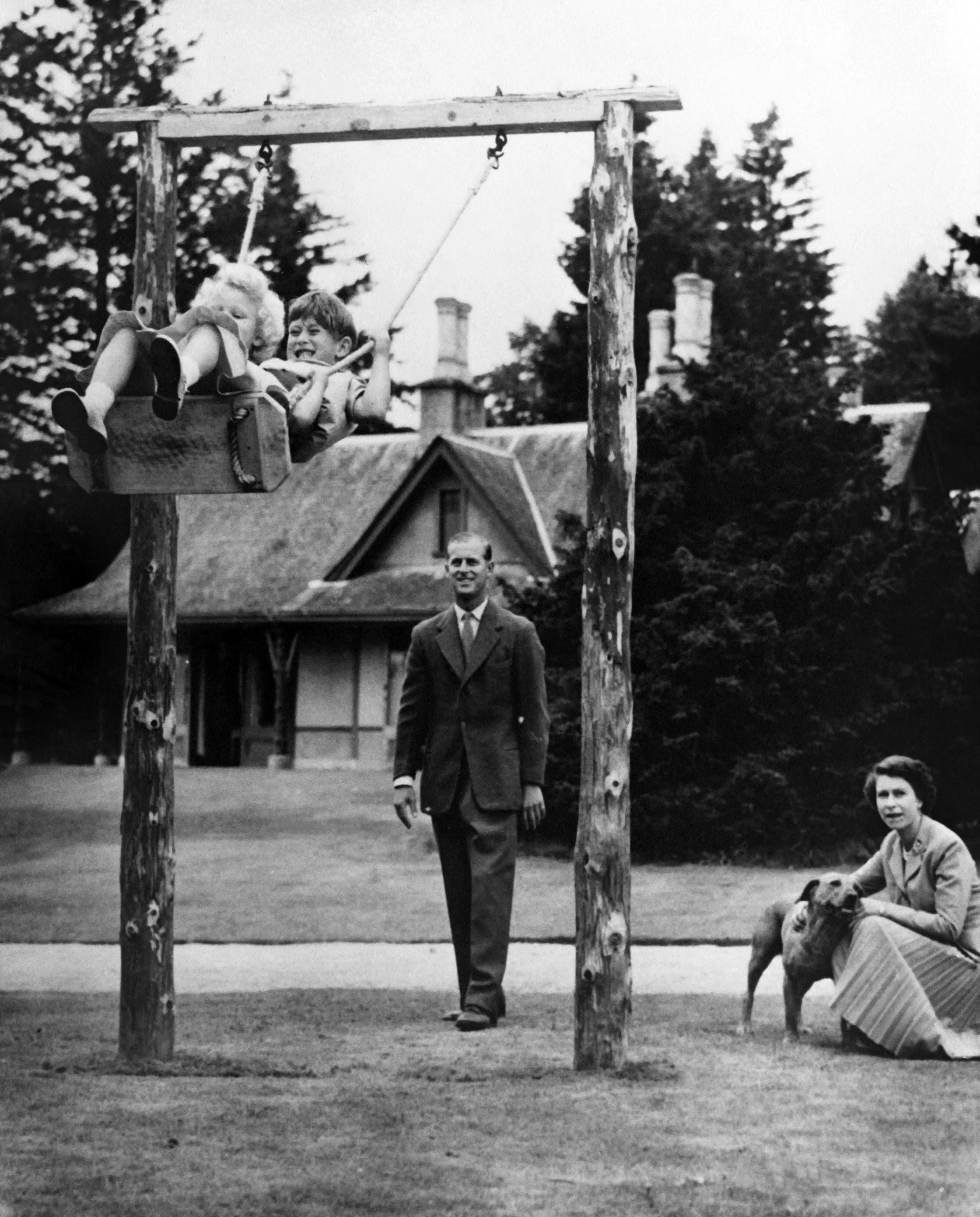 Britain's Queen Elizabeth II (right) and Prince Philip, Duke of Edinburgh (centre) play with Prince Charles and Princess Anne at Balmoral Castle in Aberdeenshire in September 1955