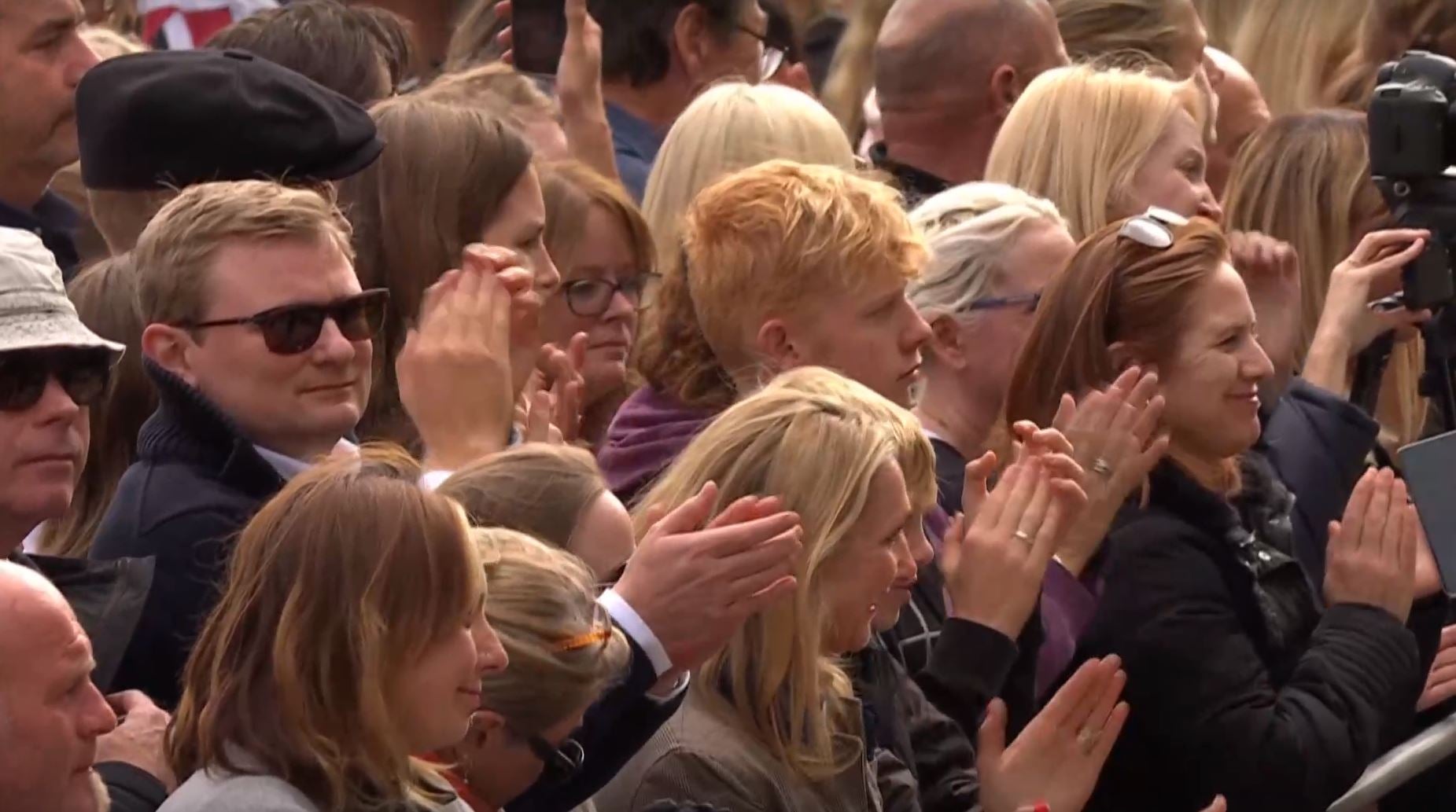 Mourners clap during the funeral procession