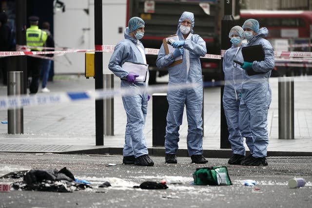 Forensics officers and police at the scene in Shaftesbury Avenue, central London, where two officers were stabbed (PA)