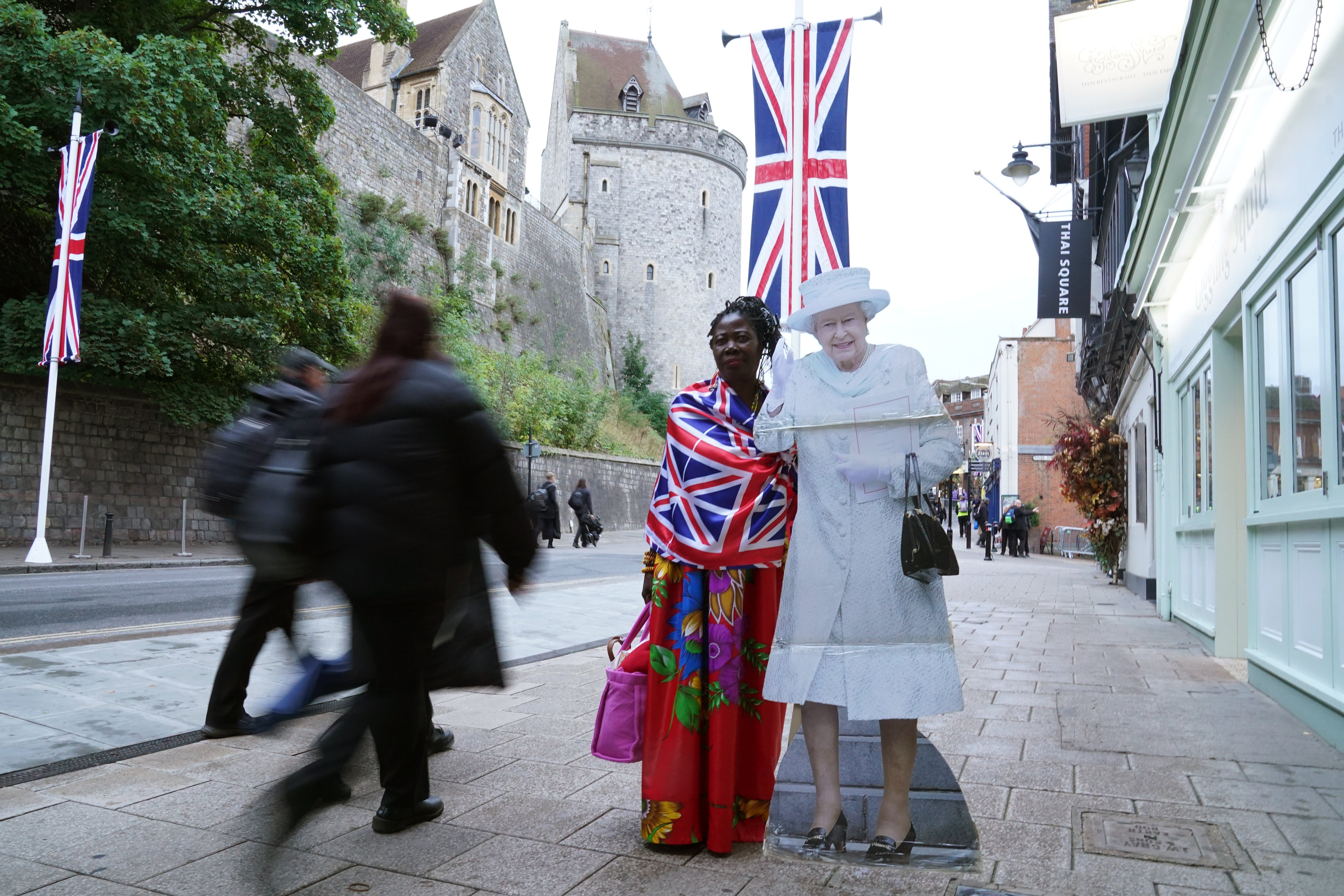 A member of the public standing next to a cardboard cut-out of the Queen in Windsor, Berkshire (Owen Humphreys/PA)