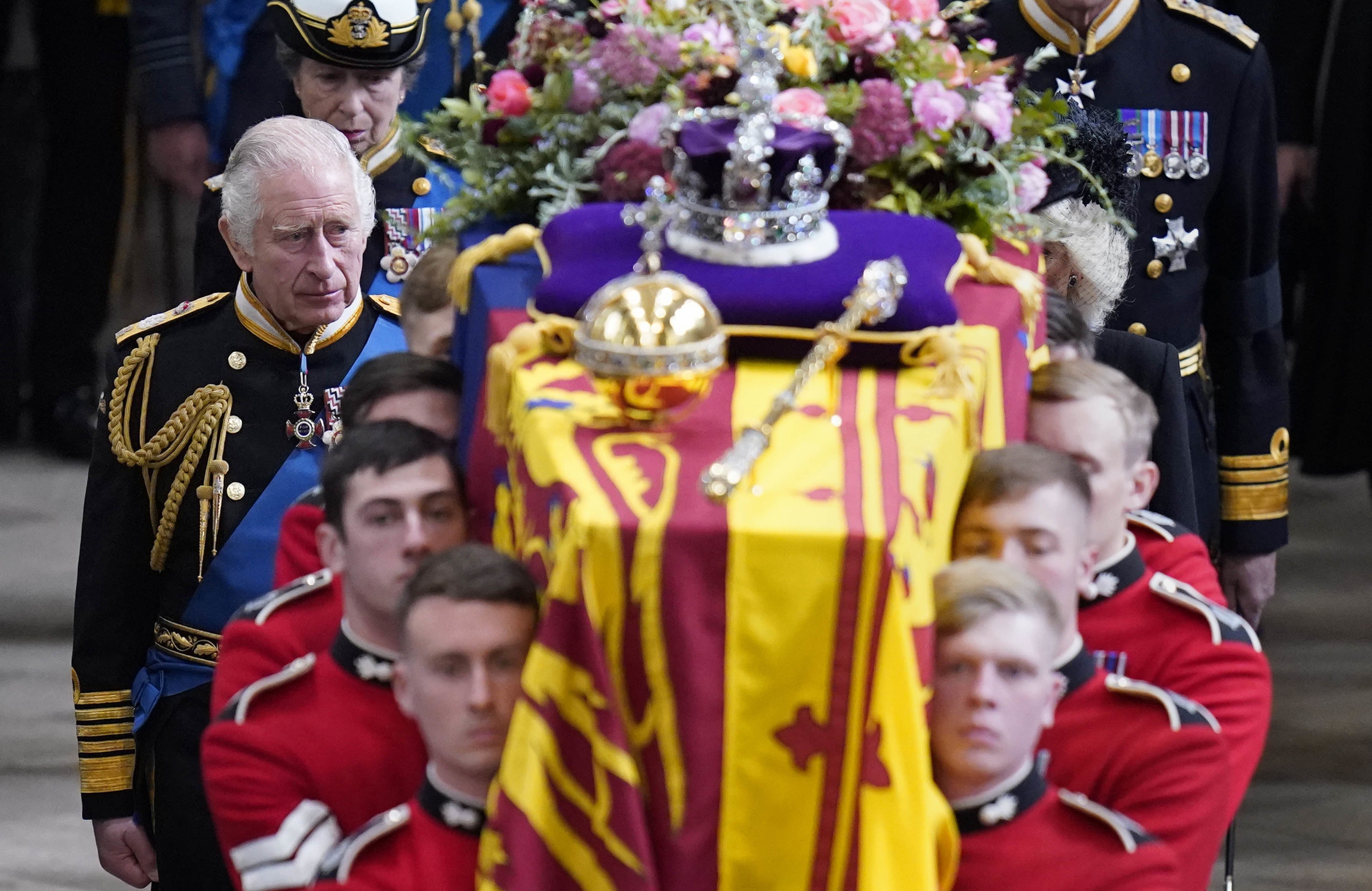 King Charles III and members of the royal family follow behind the coffin of Queen Elizabeth II, draped in the Royal Standard with the Imperial State Crown and the Sovereign’s orb and sceptre, as it is carried out of Westminster Abbey (PA)