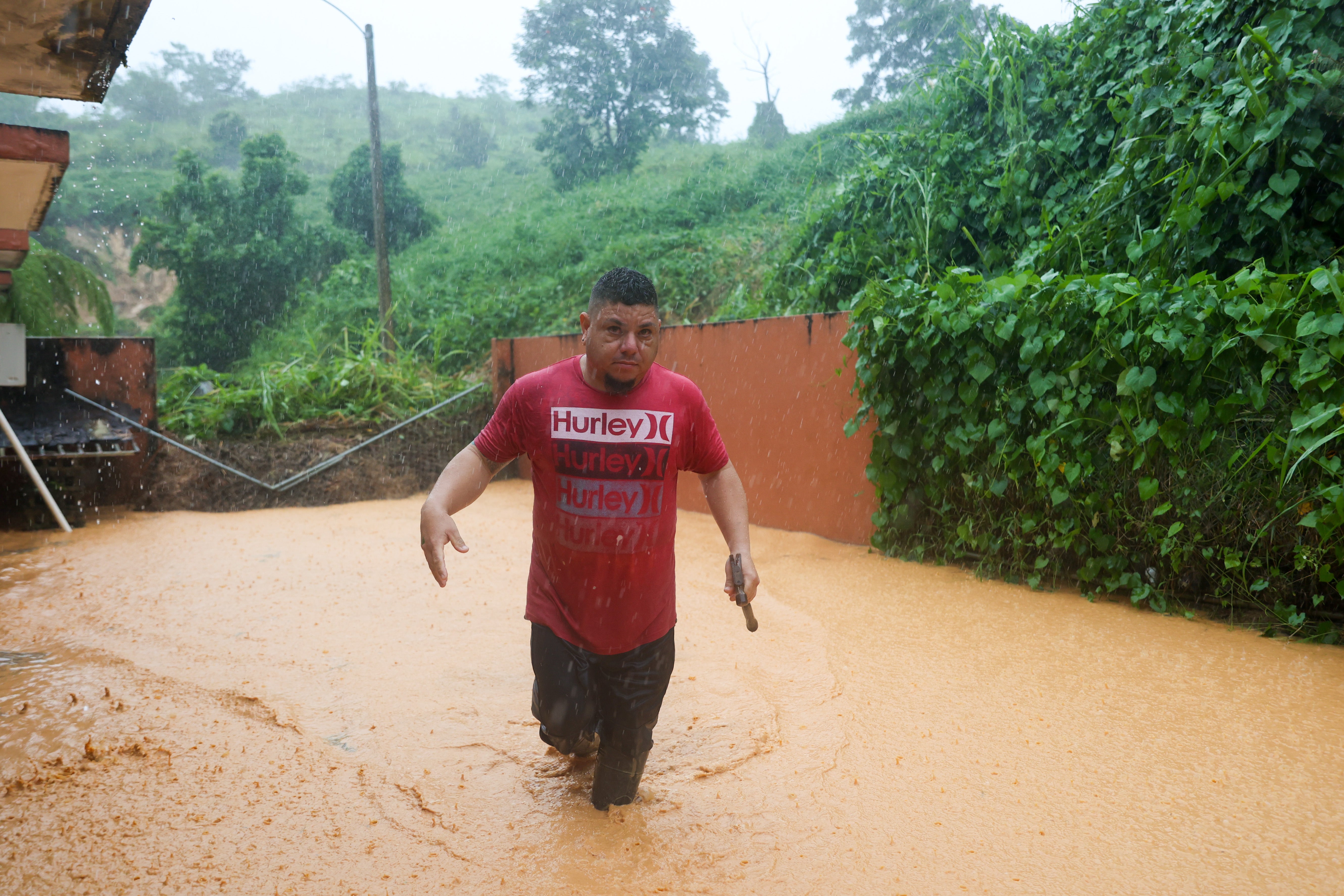 A man fords floodwaters in Cayey, Puerto Rico on Sunday