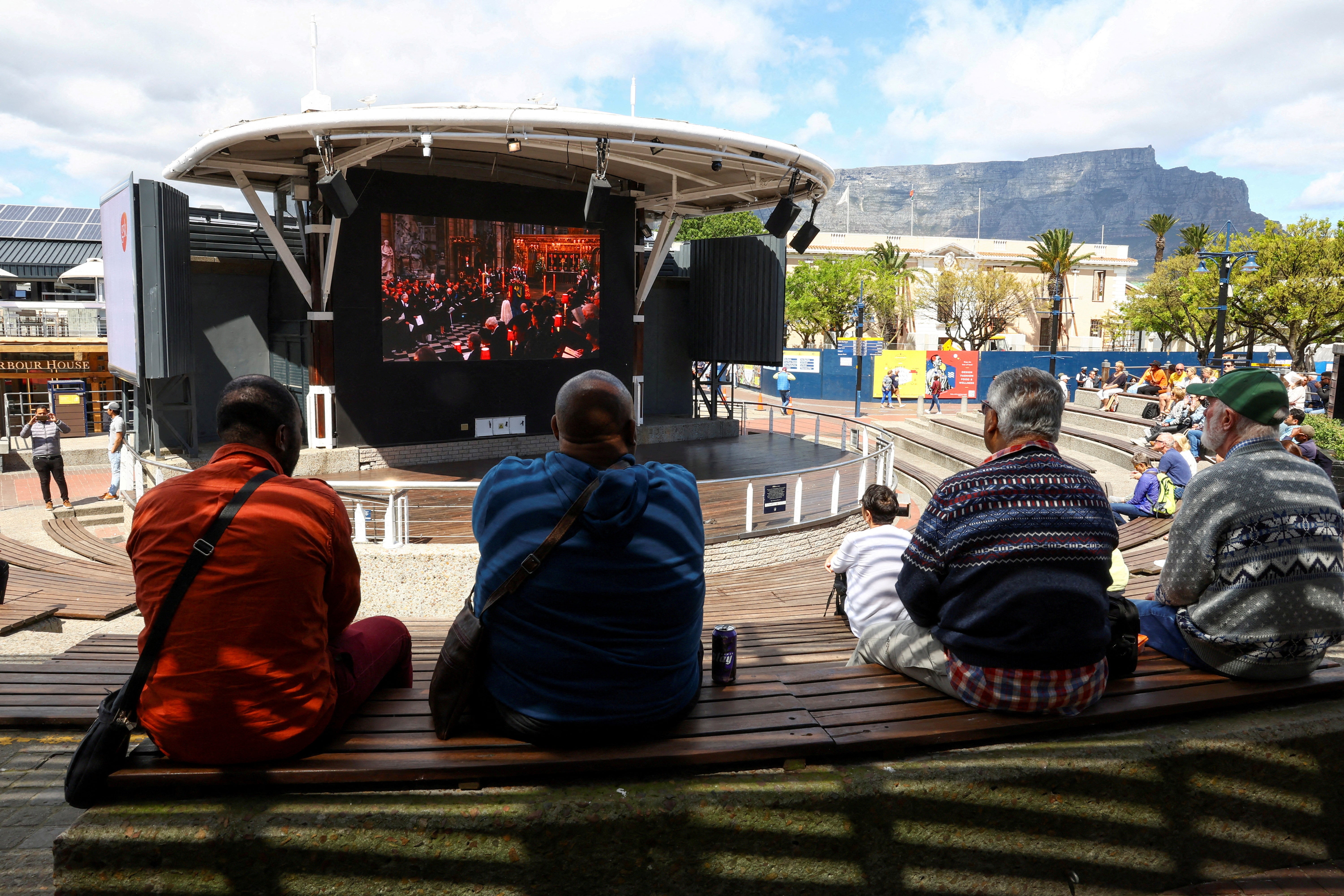 Spectators watch the service on a big screen in the V&A Waterfront in Cape Town, South Africa