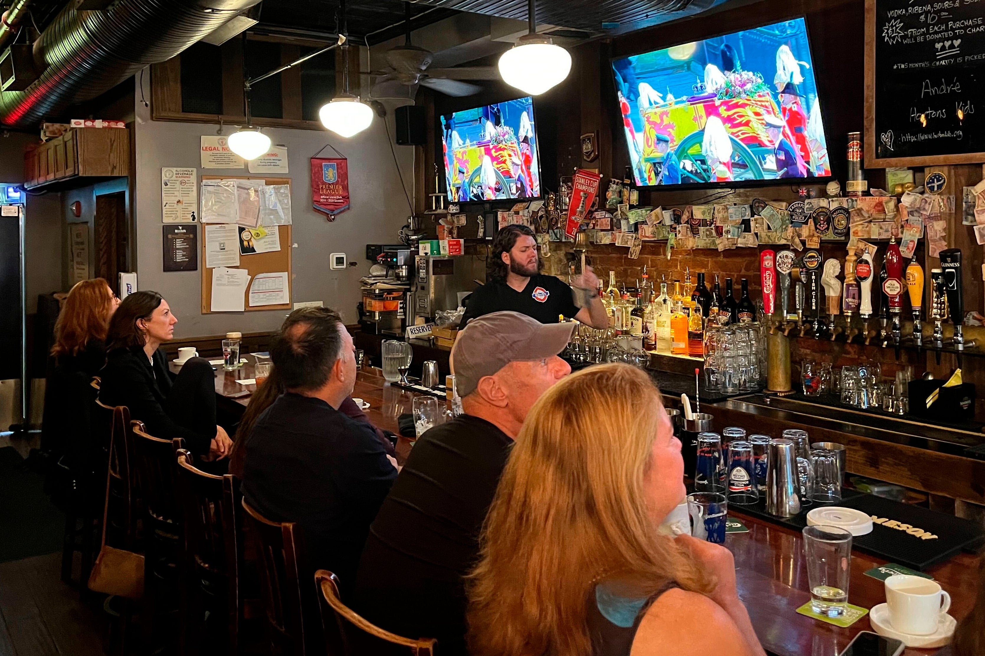 Visitors watch coverage of the funeral procession at The Queen Vic, a British pub in Washington