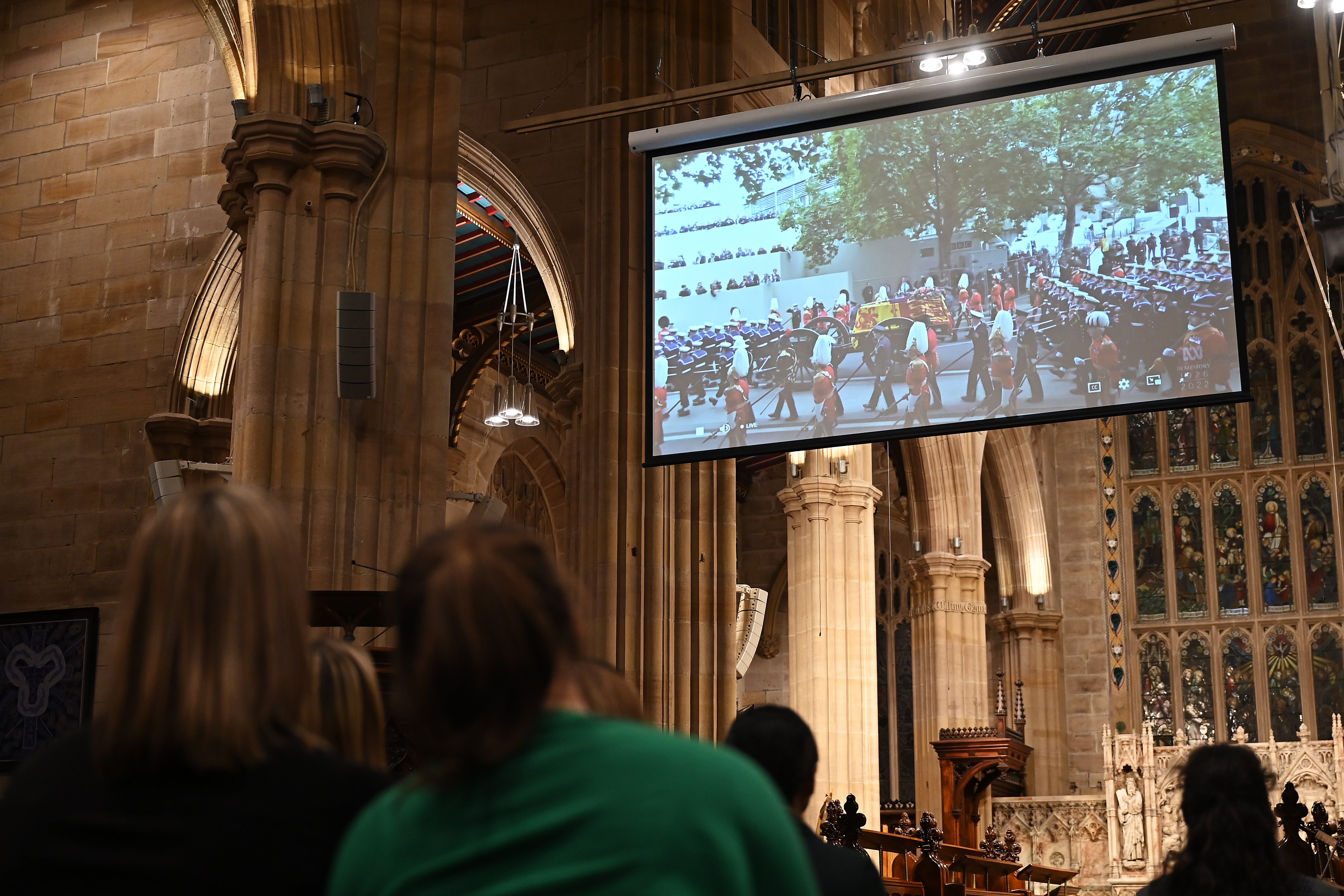 Members of the public watch a live stream of funeral during a Memorial Service at St Andrew's Cathedral in Sydney, Australia