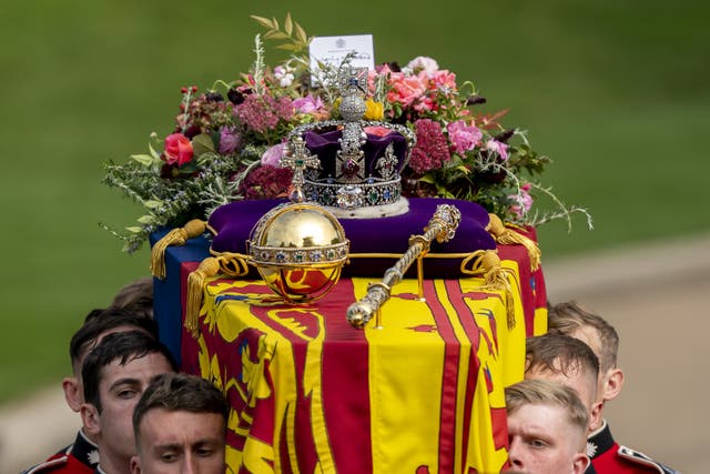 The coffin of the Queen, draped in the Royal Standard with the Imperial State Crown and the Sovereign’s orb and sceptre (PA)
