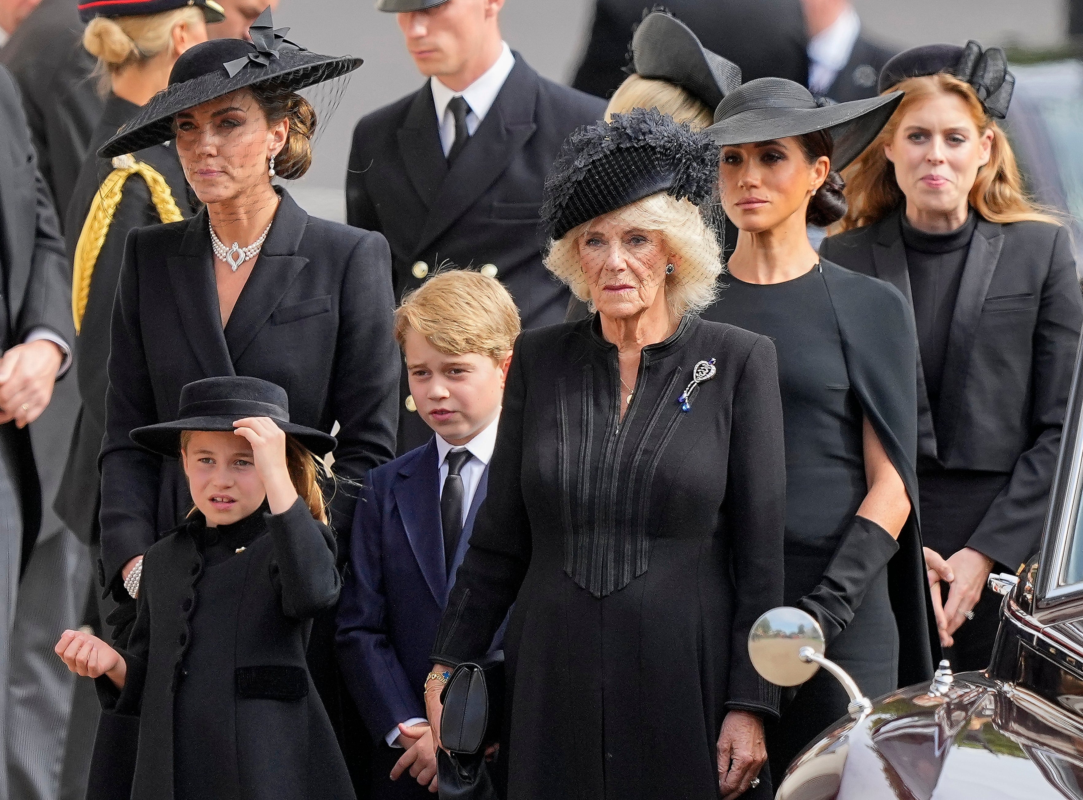 Kate, Princess of Wales, from left, Princess Charlotte, Prince George, Camilla, the Queen Consort, Meghan, Duchess of Sussex and Princess Beatrice follow the coffin