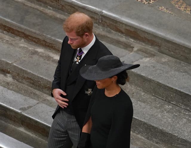 The Duke and Duchess of Sussex follow the bearer party with the coffin of Queen Elizabeth II (Gareth Fuller/PA)