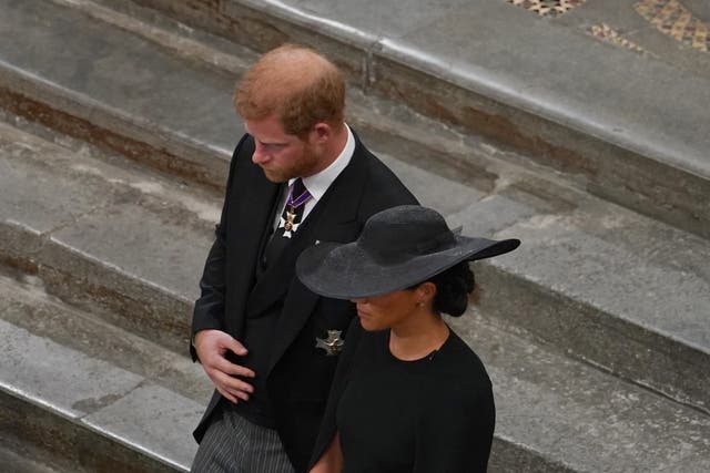 The Duke and Duchess of Sussex follow the bearer party with the coffin of Queen Elizabeth II (Gareth Fuller/PA)