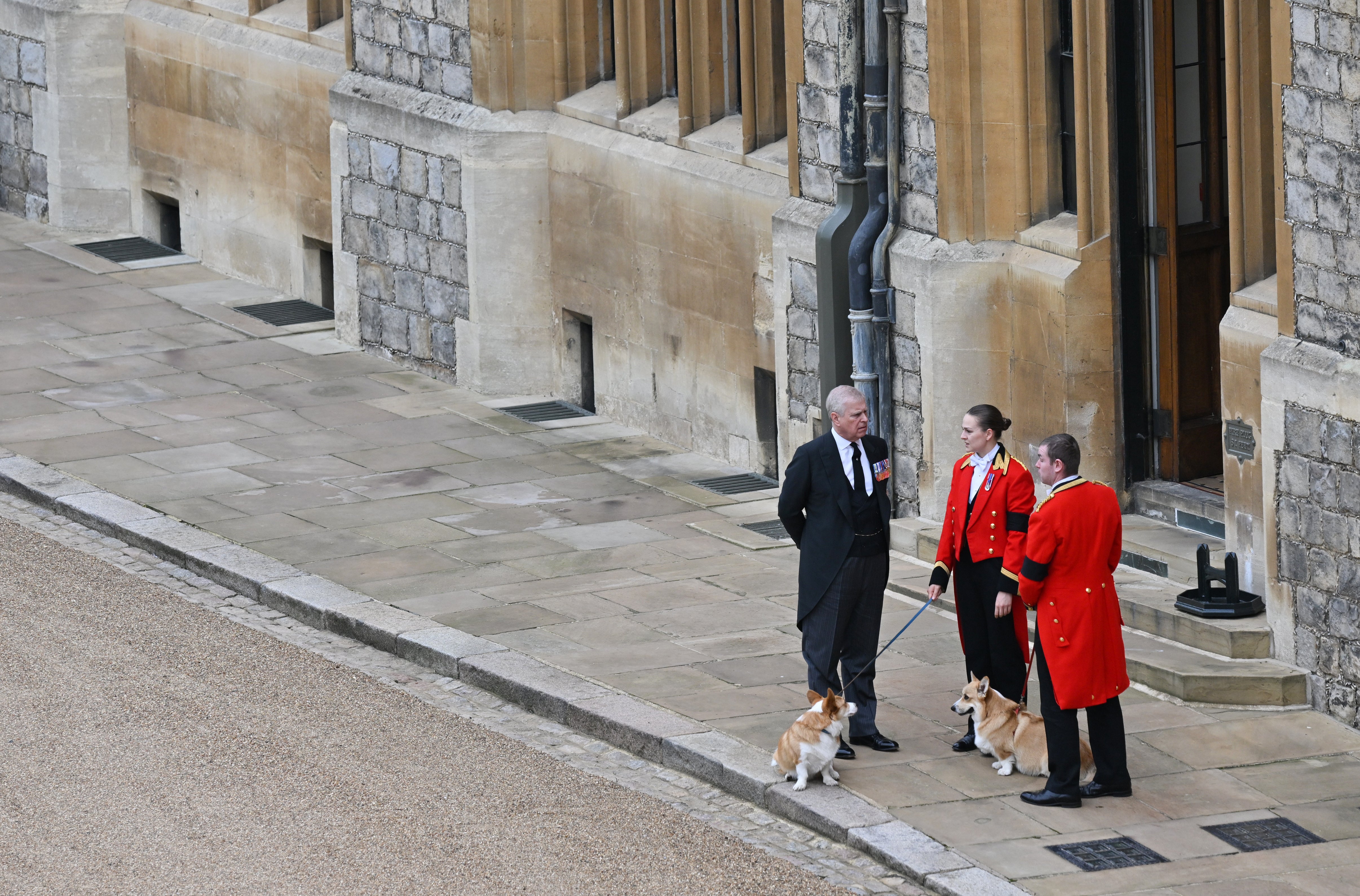 The Queen’s two corgis, Muick and Sandy, with the Duke of York and footmen during the procession through Windsor Castle (Glyn Kirk/PA)