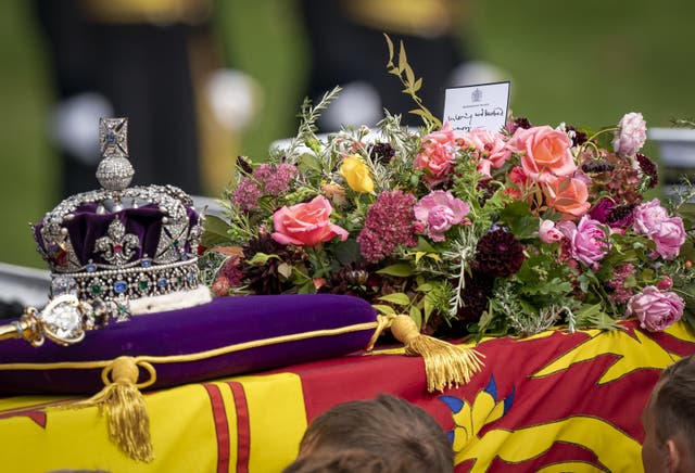 The coffin of Queen Elizabeth II, draped in the Royal Standard with the Imperial State Crown and the sovereign’s orb and sceptre, in the ceremonial procession following her state funeral in London. (Jane Barlow/PA)
