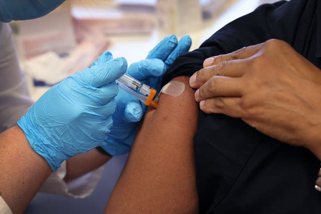 <p>A woman receives a Covid-19 vaccine in New York</p>