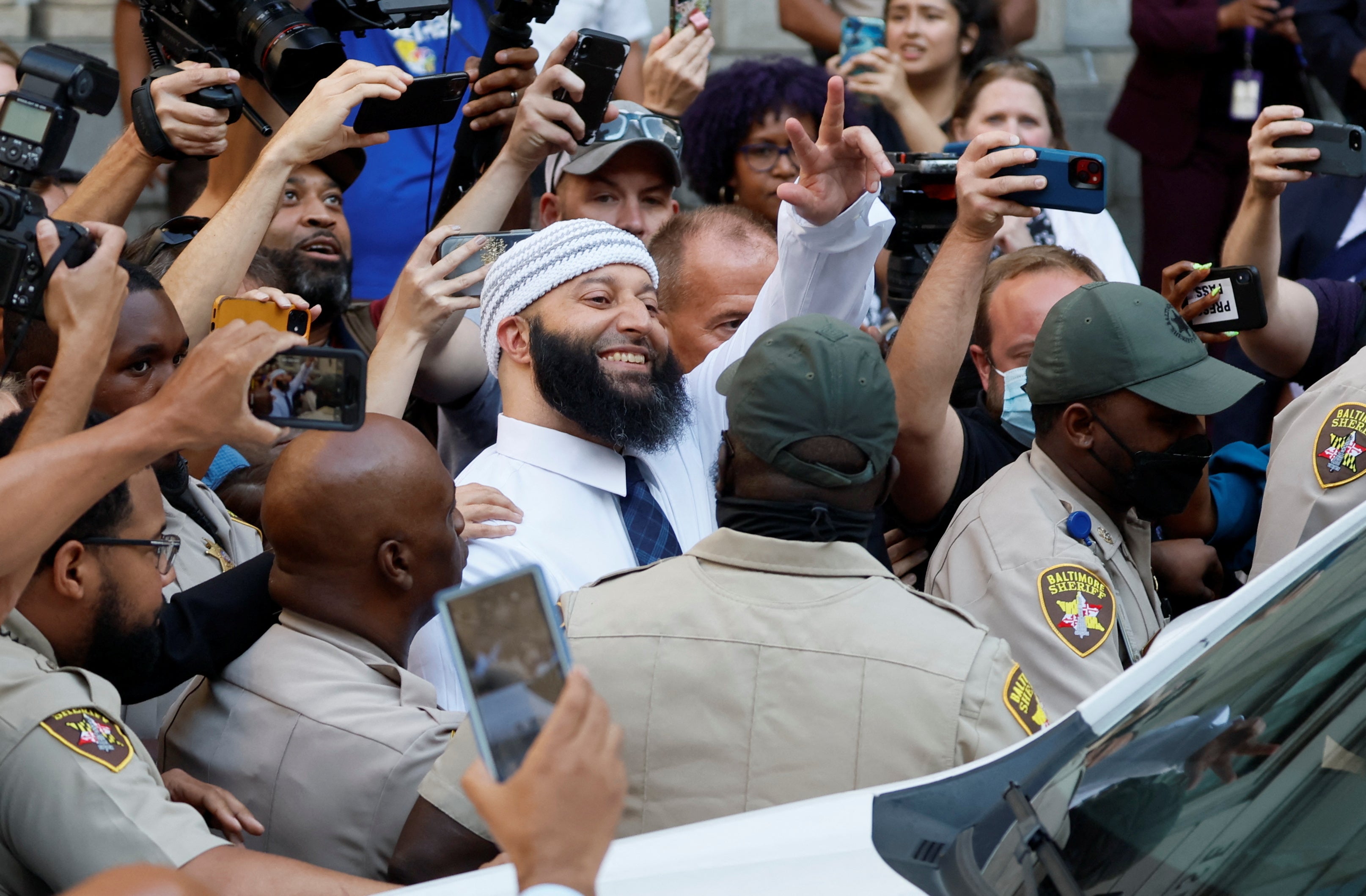 Adnan Syed flashes peace sign as he walks out of the courthouse on Monday