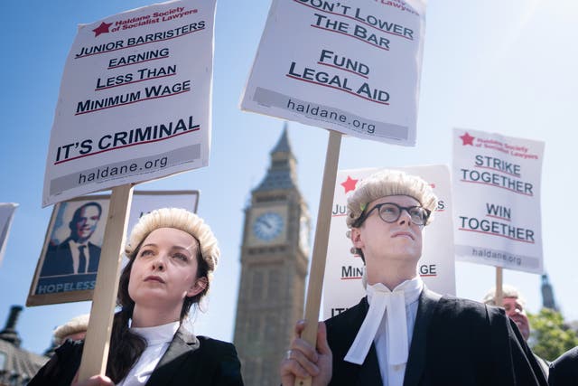 Criminal defence barristers outside the Houses of Parliament in London this July as they support the ongoing Criminal Bar Association action over Government set fees for legal aid advocacy work (Stefan Rousseau/PA)