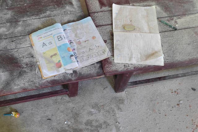 <p>An alphabet book and a notebook at a middle school in Let Yet Kone village in Tabayin township in the Sagaing region where 13 children were killed in September 2022 </p>