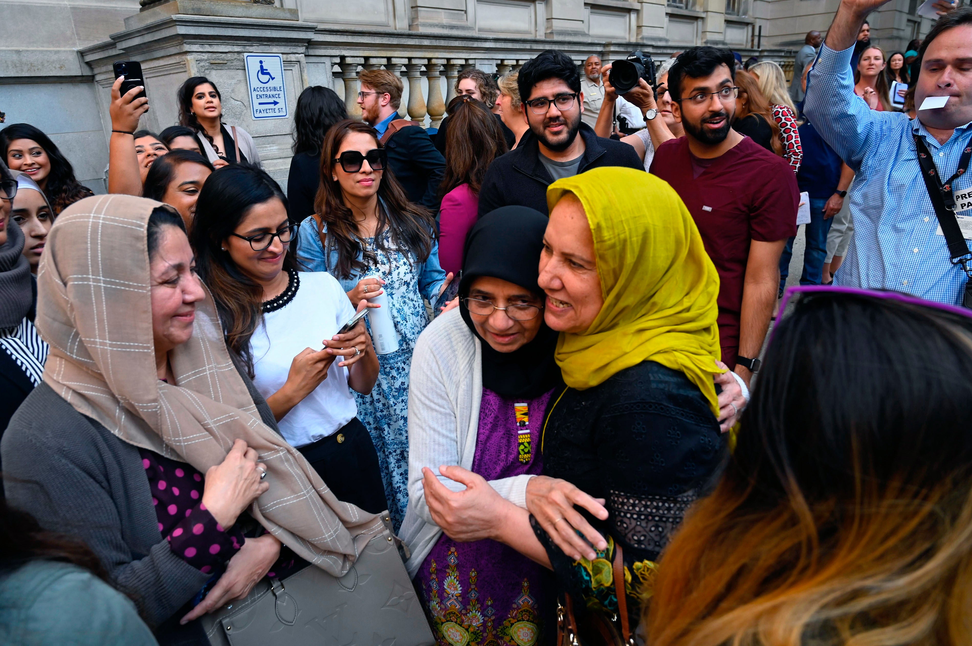 Adnan Syed’s mother, Shamim Syed, center right, celebrates with friends outside of the courthouse on Monday