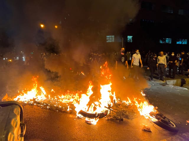 <p>A police motorcycle burns during a protest over the death of Mahsa Amini</p>