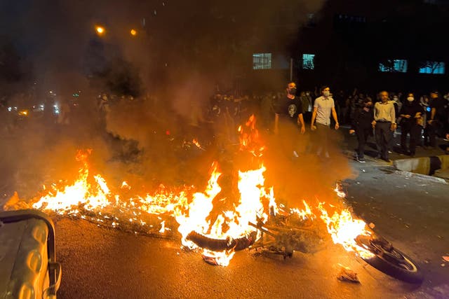 Una moto de la policía se quema durante una protesta por la muerte de Mahsa Amini