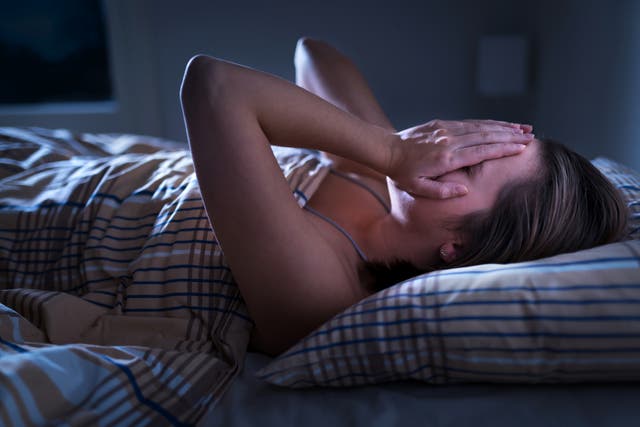 <p>Representational image of sleepless woman awake and covering face in the middle of the night </p>