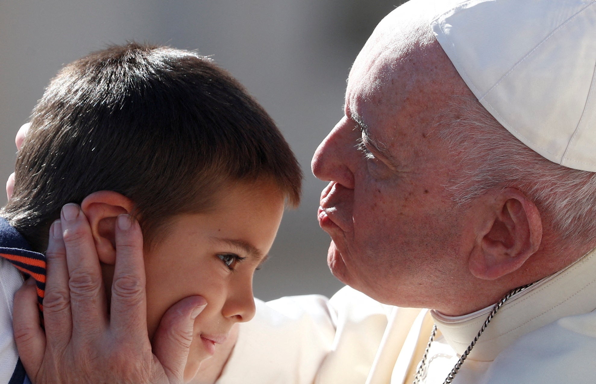 Pope Francis kisses a kid on his forehead during the weekly general audience at the Vatican on Wednesday