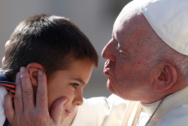 <p>Pope Francis kisses a kid on his forehead during the weekly general audience at the Vatican on Wednesday</p>