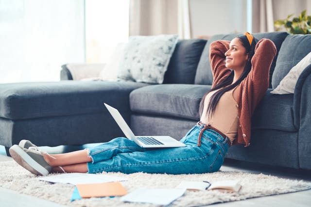 <p>Shot of a young woman relaxing while working in the living room at home</p>