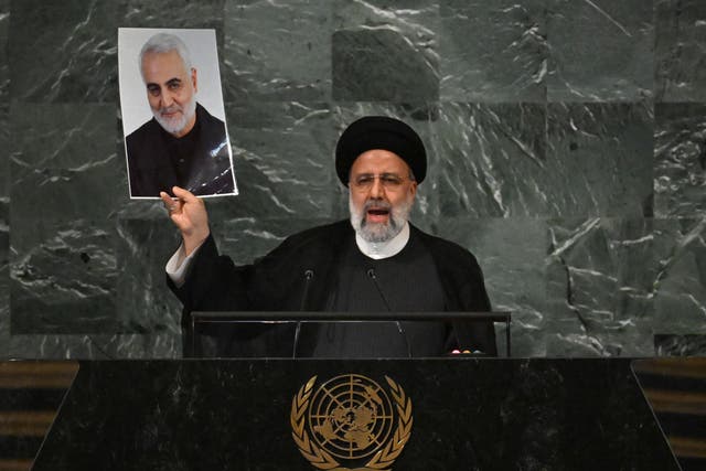 <p>Iranian President Ebrahim Raisi addresses the 77th session of the United Nations General Assembly while holding a photo of Iranian General Qasem Soleimani killed by a US drone strike in Baghdad in January 2020</p>