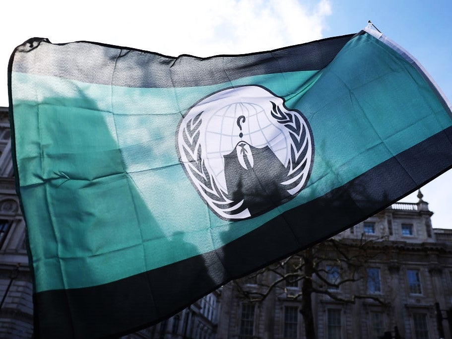 A demonstrator waves an ‘Anonymous’ hacking group flag during a protest in London on 2 April, 2022