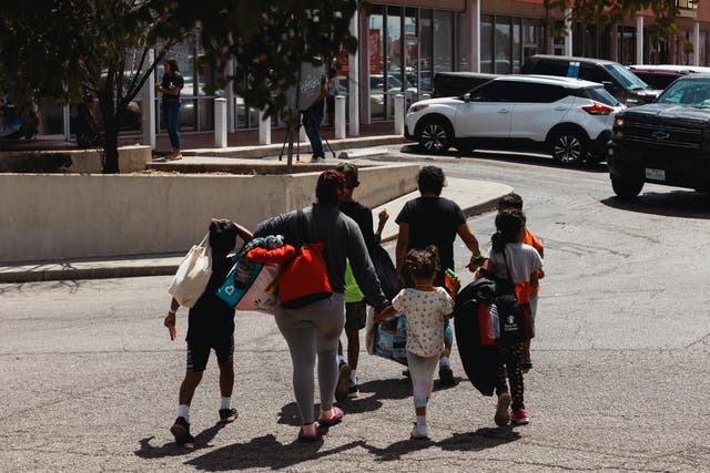<p>A groups of migrants walk in San Antonio, Texas</p>