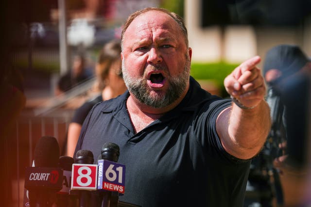 <p>InfoWars founder Alex Jones speaks to the media outside Waterbury Superior Court during his defamation trial in Connecticut</p>