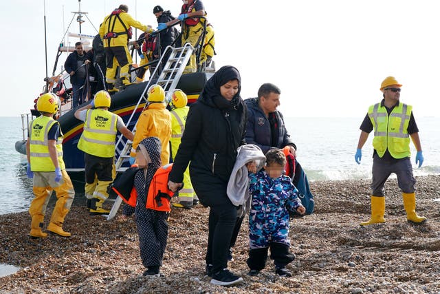 <p>A young family are helped to shore in Dungeness, Kent, after being rescued in the Channel by the RNLI </p>
