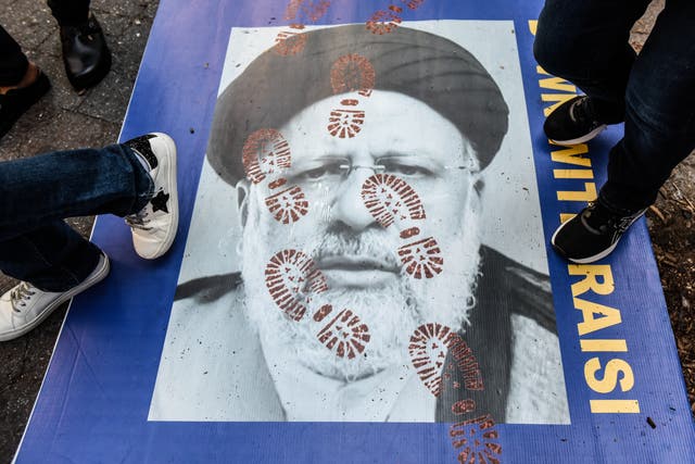 La gente pisa un cartel del presidente iraní Ebrahim Raisi mientras participa en una protesta frente a las Naciones Unidas.