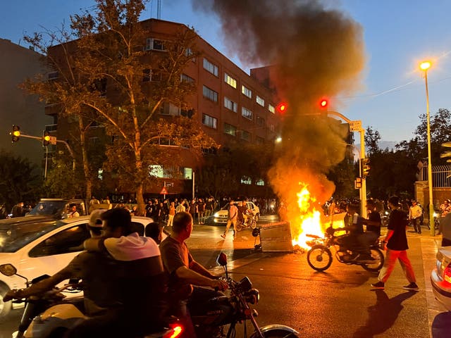 <p>A police motorcycle burns during a protest over the death of Mahsa Amini</p>