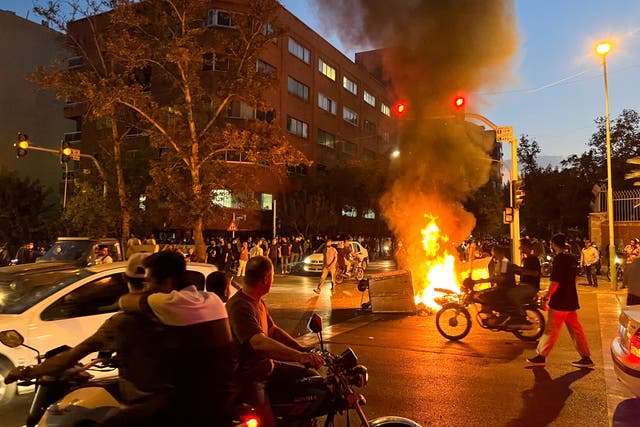<p>A police motorcycle burns during a protest over the death of Mahsa Amini</p>