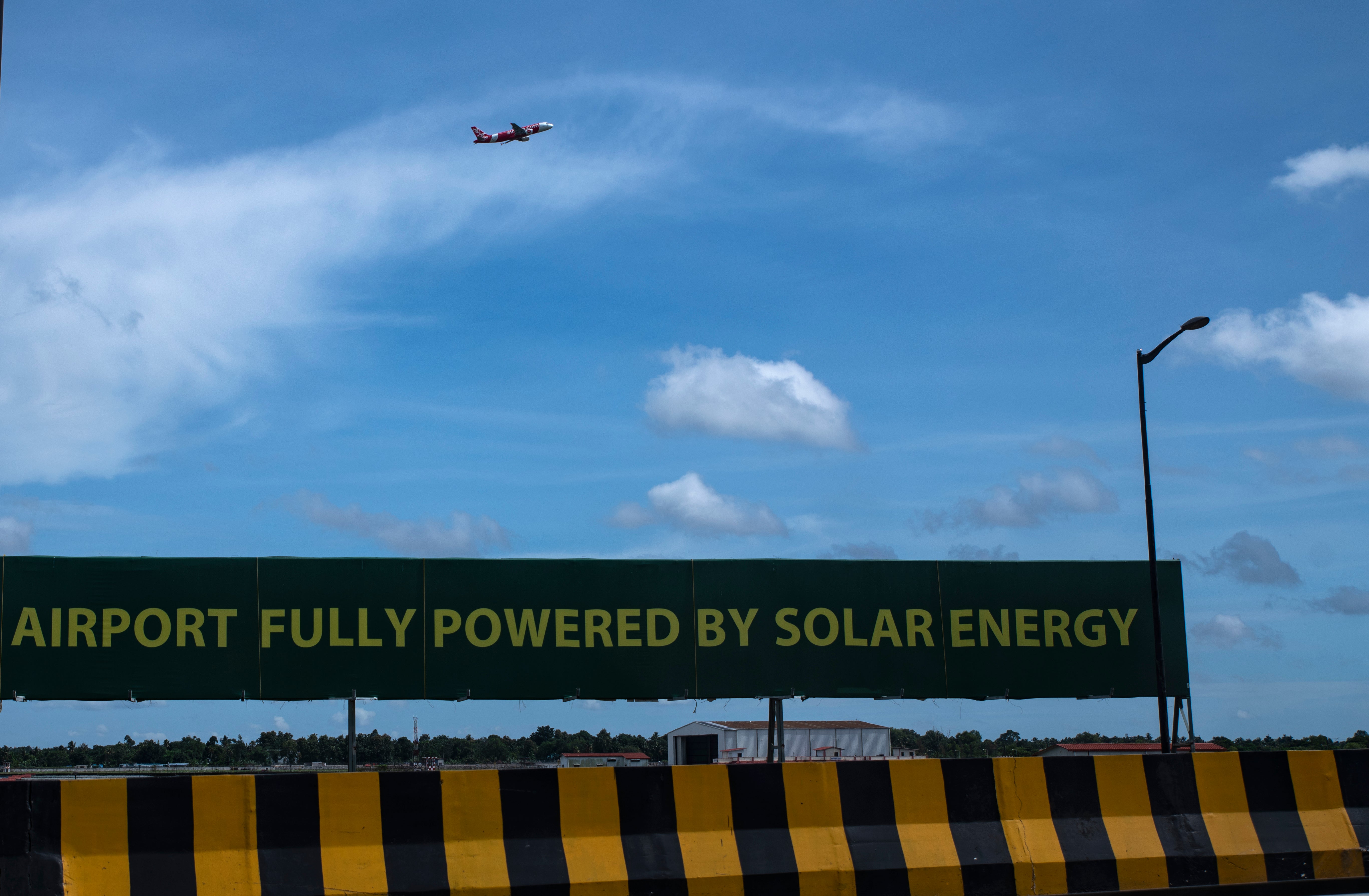 An aircraft takes off from the Cochin International Airport behind a signage that boasts of being world’s first airport powered by solar energy in Kerala state’s Kochi city on 25 August