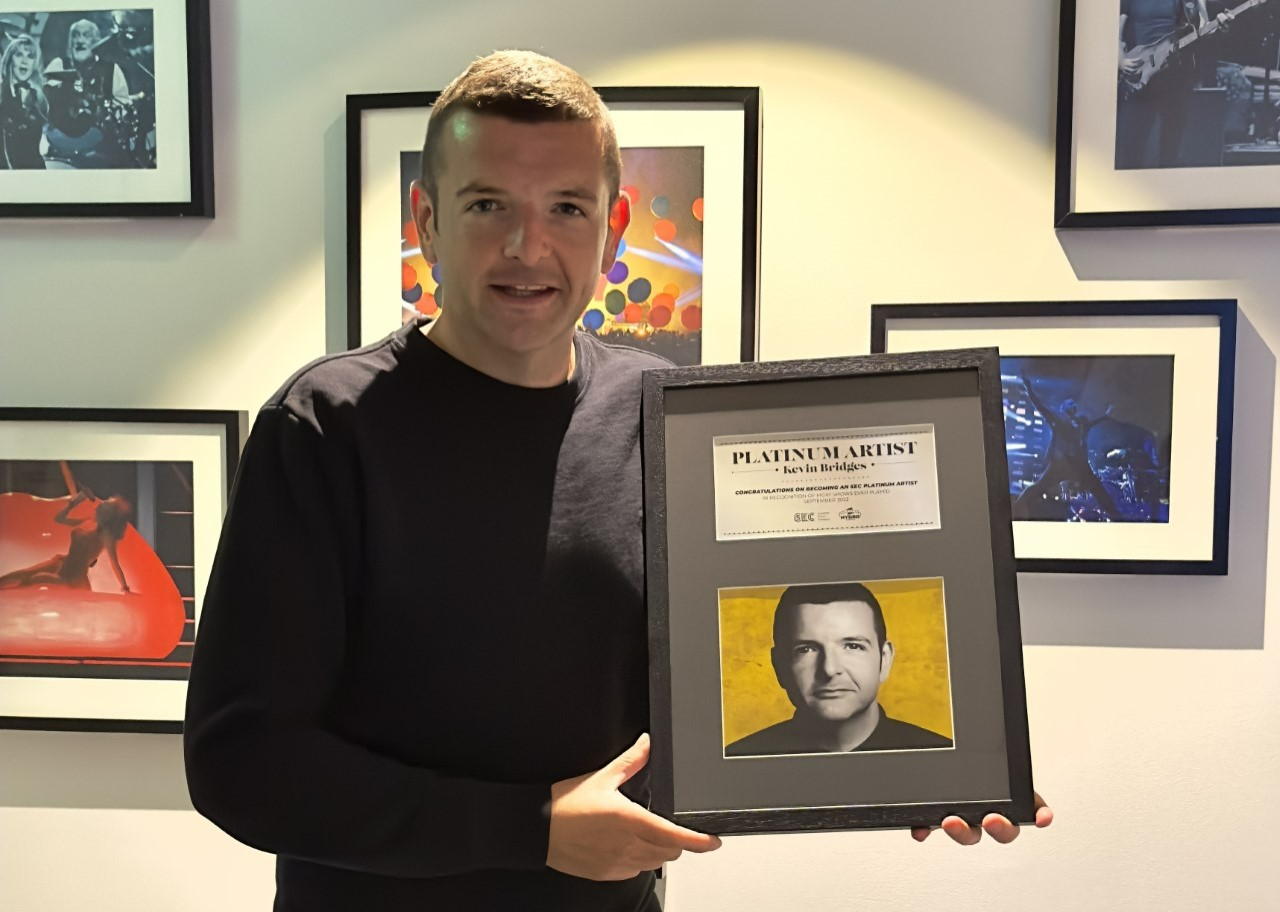Kevin Bridges holds his platinum award after his 16-night run at the Ovo Hydro in September (OVO Hydro/PA)