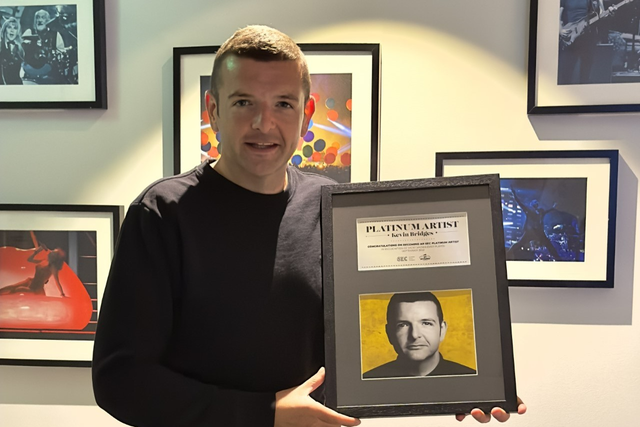Kevin Bridges holds his platinum award after his 16-night run at the Ovo Hydro in September (OVO Hydro/PA)