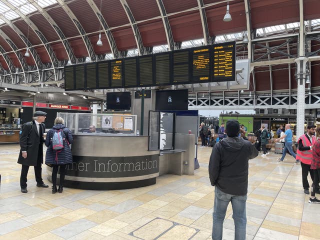 Members of the public look at the travel boards in Paddington Station (PA)