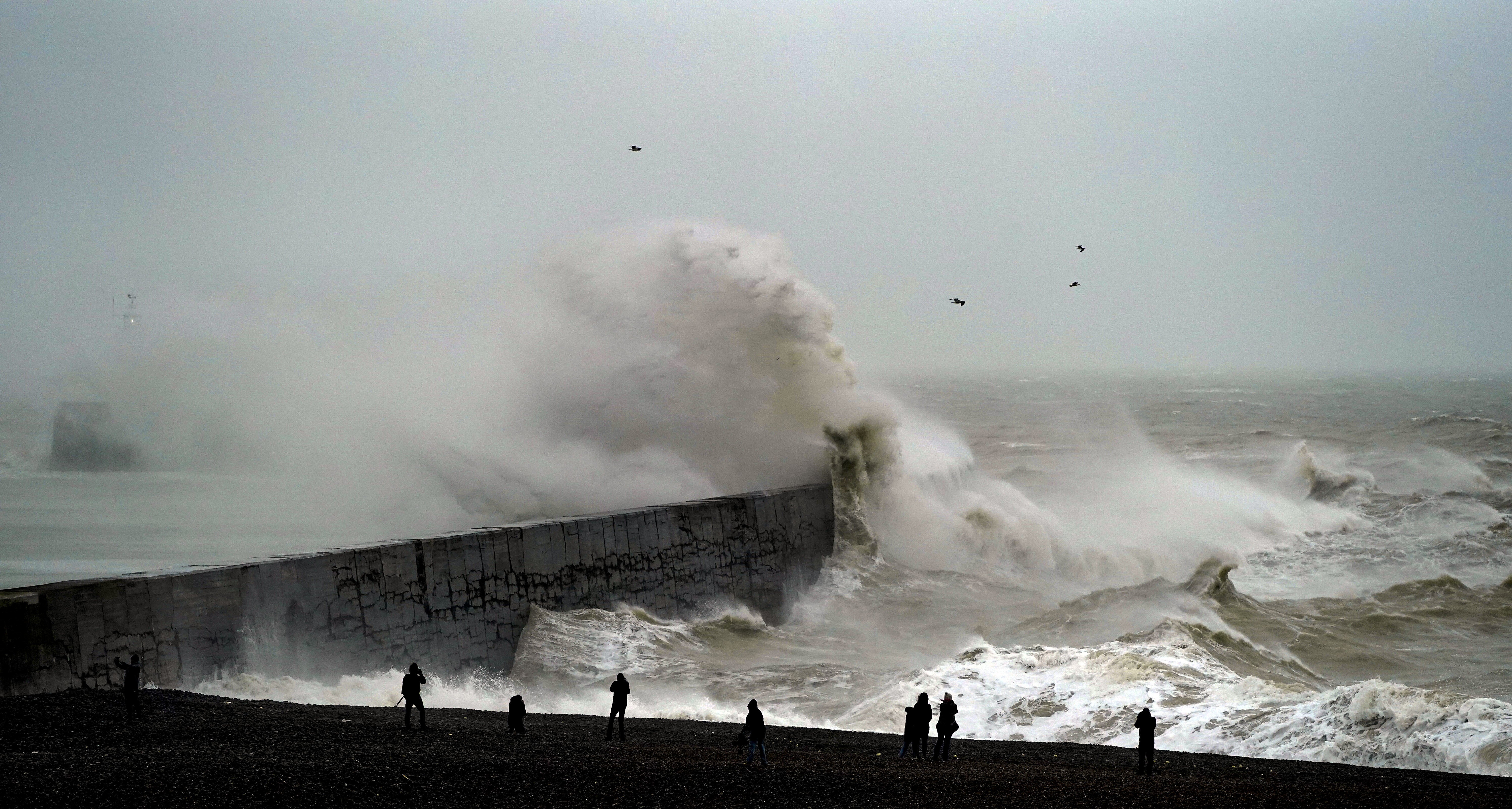A wave crashes over Newhaven lighthouse at West Quay in East Sussex (Steve Parsons/PA)