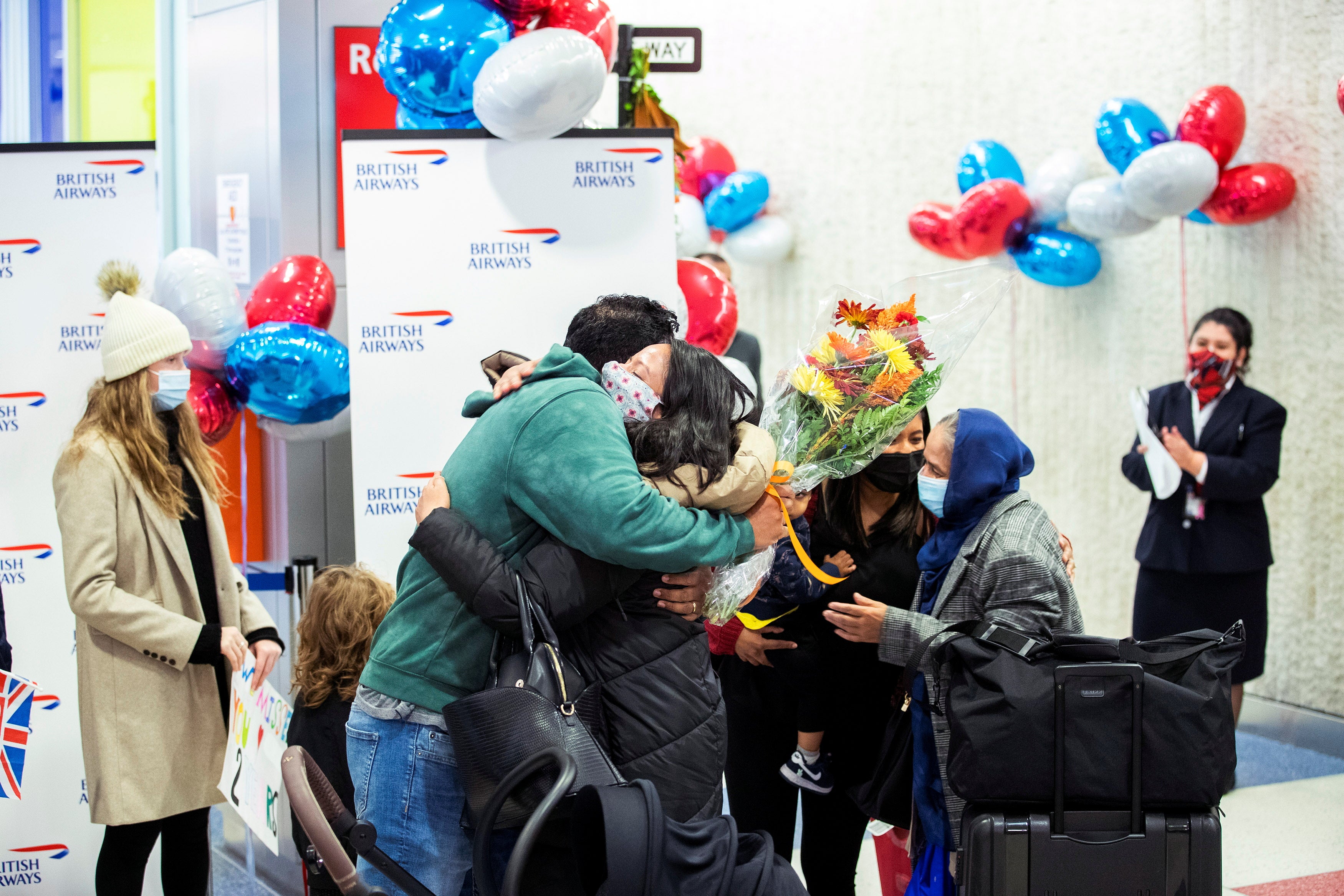 Family members embrace on 8 November 2021 as they are reunited at JFK International Airport after borders reopened between the US and the UK
