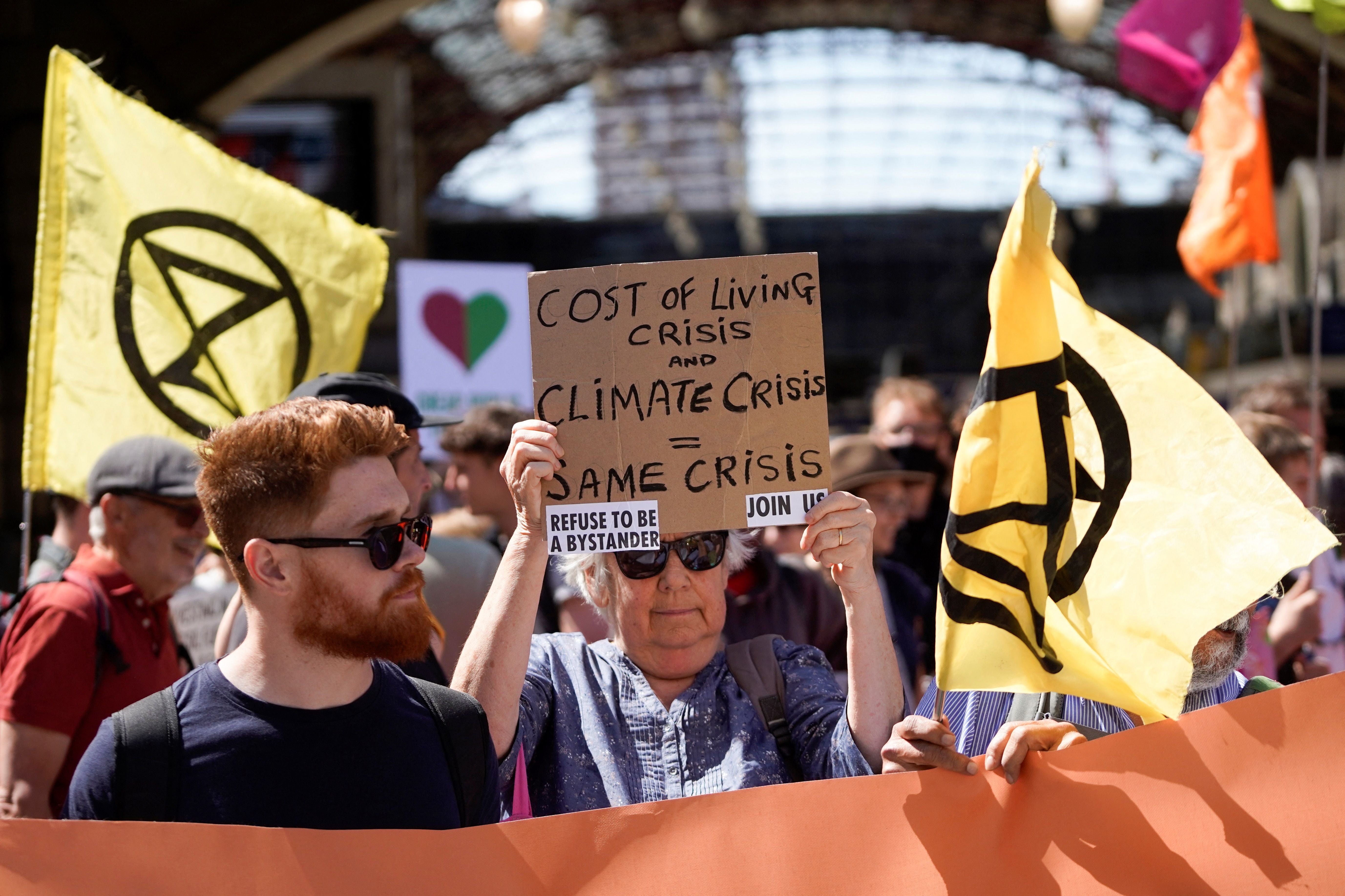 Demonstrators take part in a protest march from Victoria station to Parliament Square, in London, on July 23, 2022 to demand action over the cost of living crisis and the climate change crisis.
