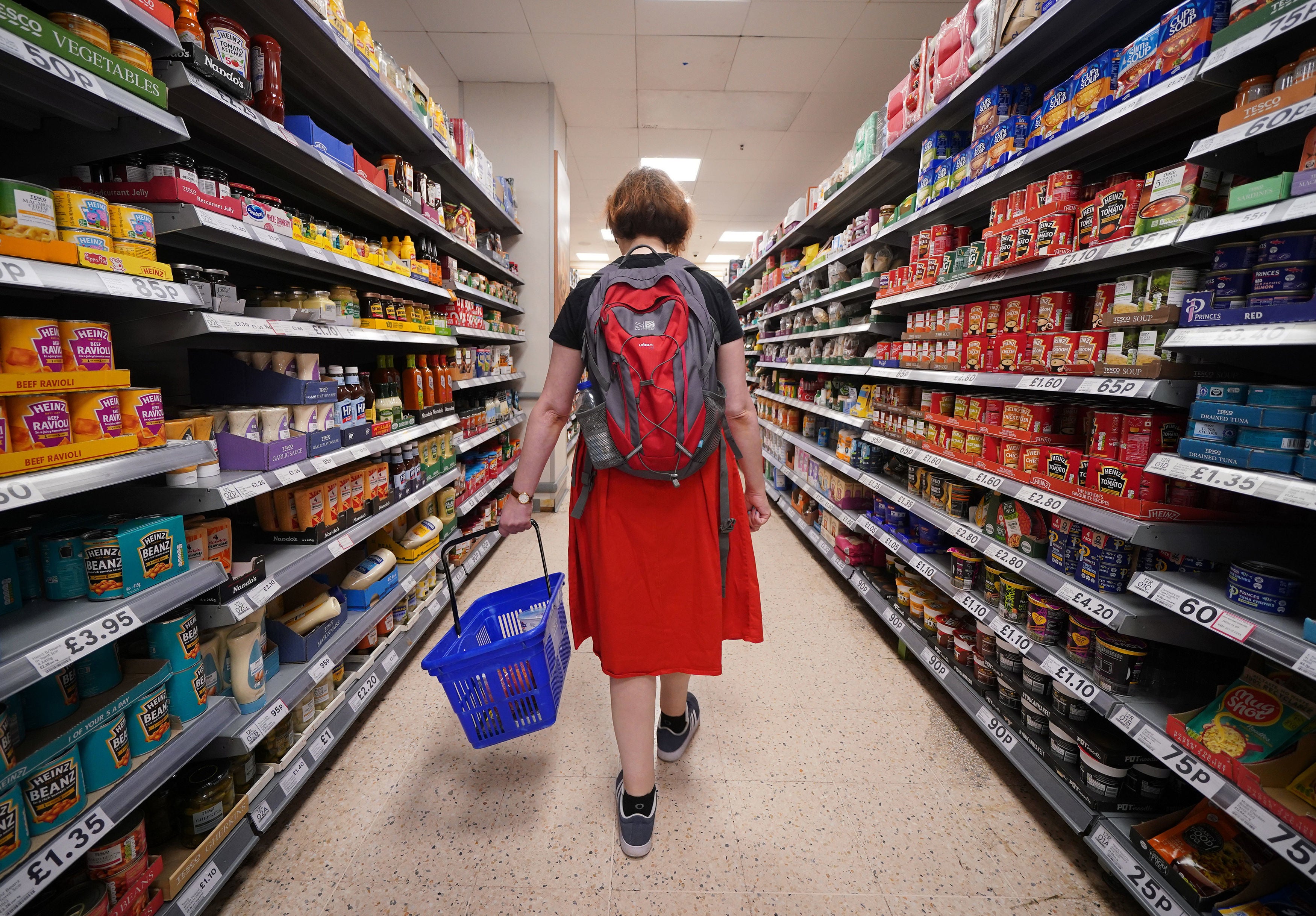 A shopper walks through a Tesco’s aisle in London
