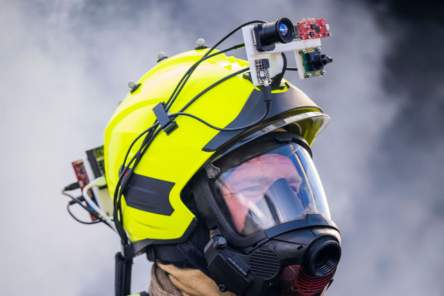 A firefighter wears a helmet enhanced with sensors and cameras allowing them to locate victims more quickly (Craig Watt/PA)