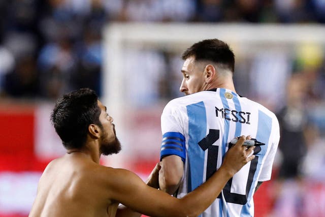 <p>A fan approaches Lionel Messi before asking the Argentina captain to sign his back</p>