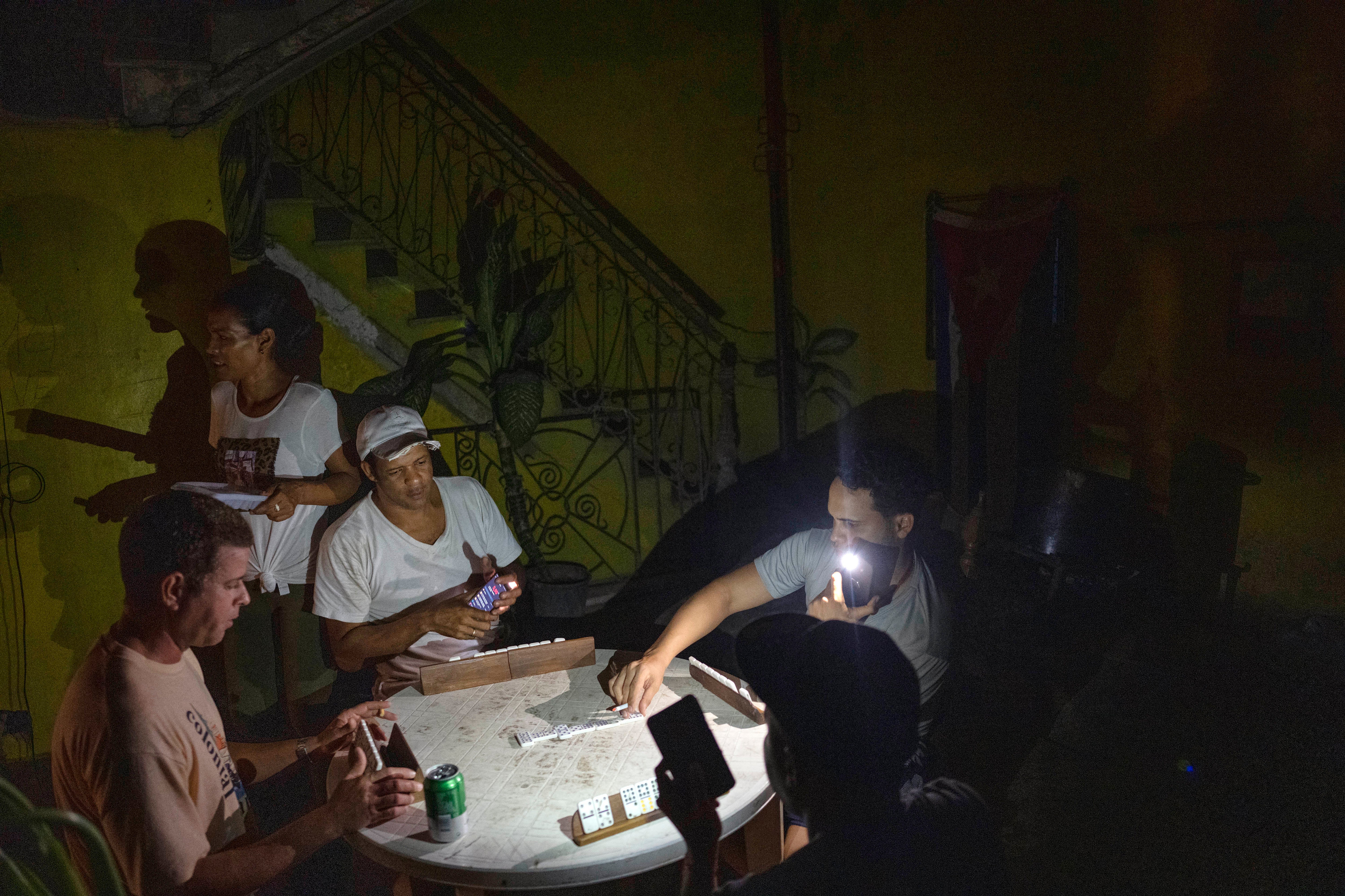 People play dominoes by flashlight during a blackout in Havana, Cuba, on Wednesday.