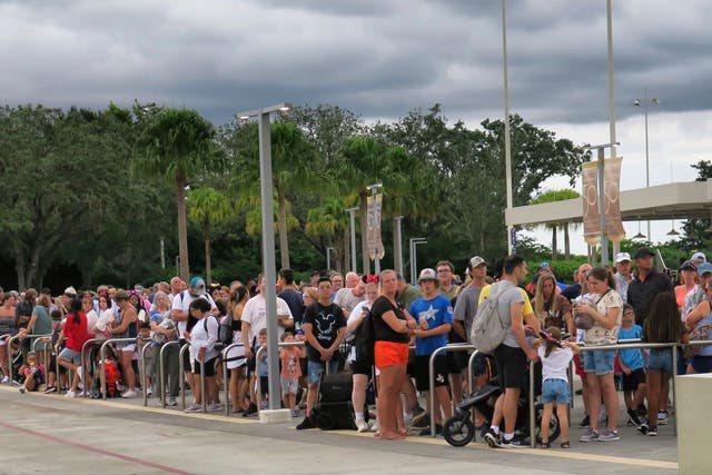 <p>Guests wait for tram transportation at the Magic Kingdom at Walt Disney World on Tuesday ahead of the park closing on Wednesday</p>