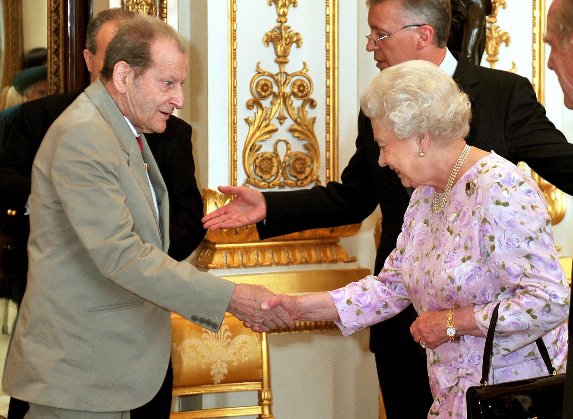 Queen Elizabeth II shakes hands with artist, Lucian Freud before lunch for members of the Order of Merit at Buckingham Palace in London (John Stillwell/PA)