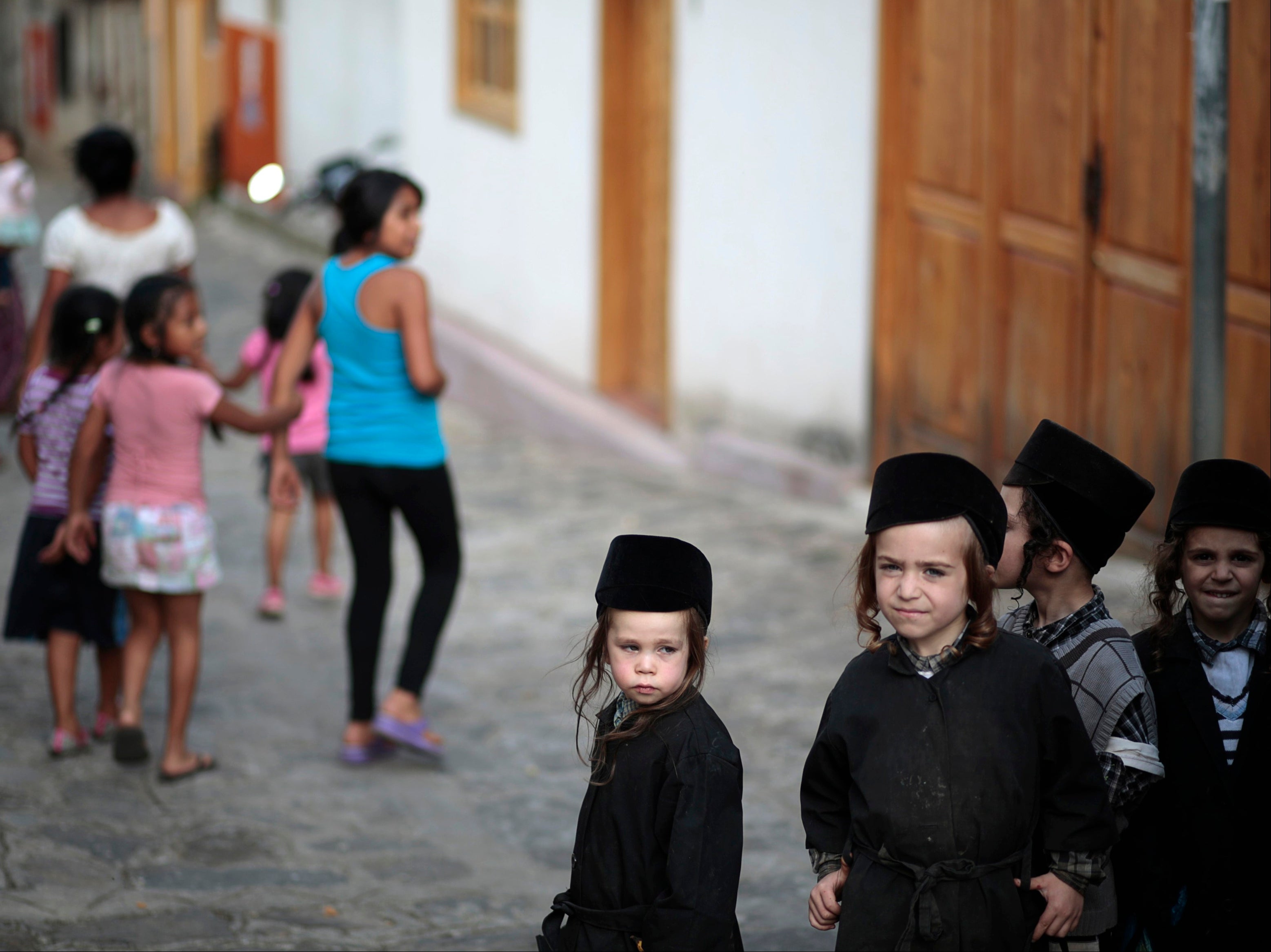 Children of a Jewish community stand on a street in the village of San Juan La Laguna August 24, 2014. A few months after moving from Canada to a remote part of Guatemala to find religious freedom, the group of ultra orthodox Jews have been forced out of their homes in a bitter conflict with hostile villagers. The Lev Tahor community packed its bags on Friday in San Juan la Laguna, west of Guatemala City, to board buses bound for the capital after weeks of friction with sections of the local population.
