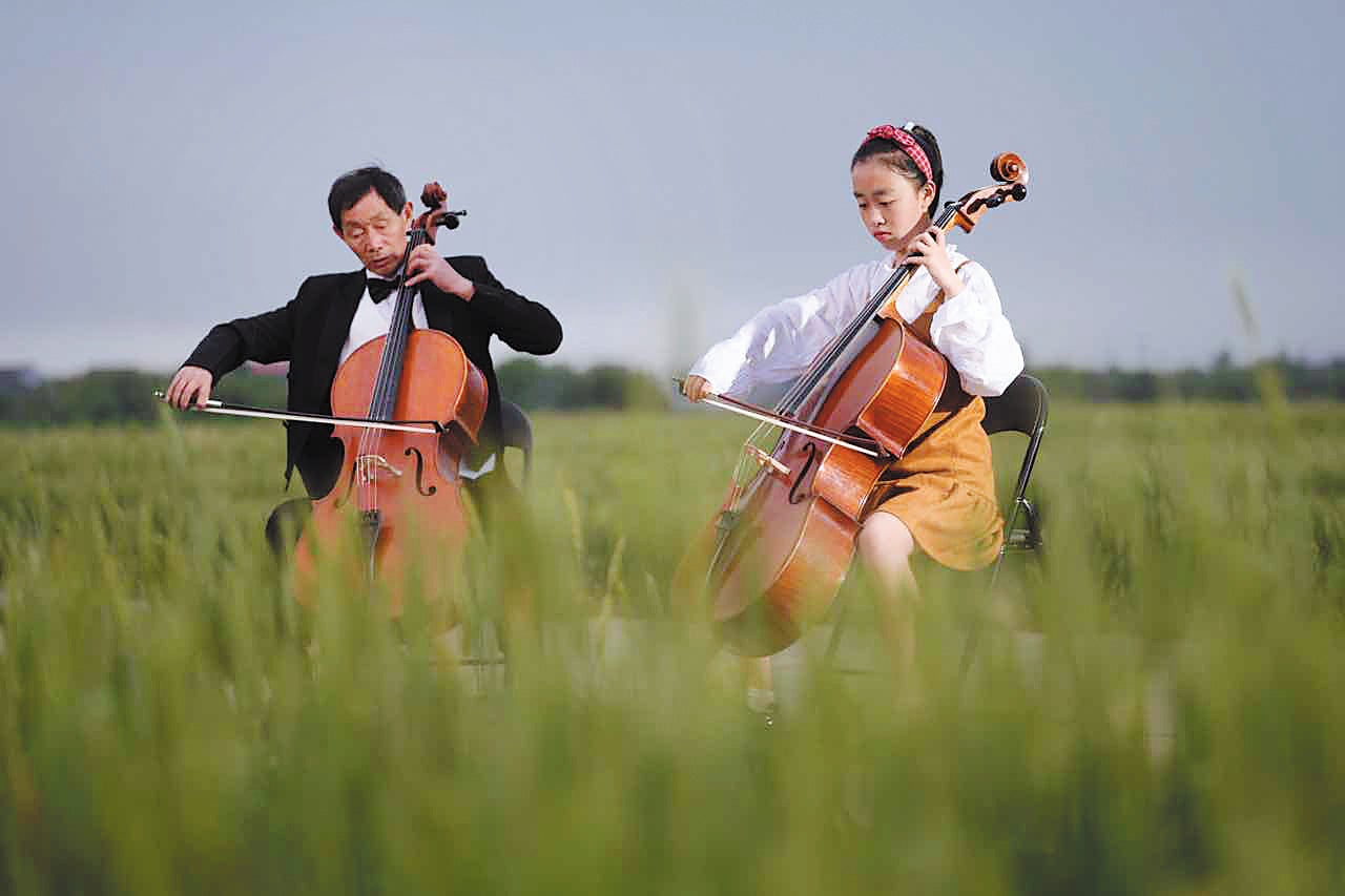 Chen Shuaiping and his granddaughter, Zhang Yuanyuan, perform in a concert held in the rice paddies in Xianxiang, Zhejiang province