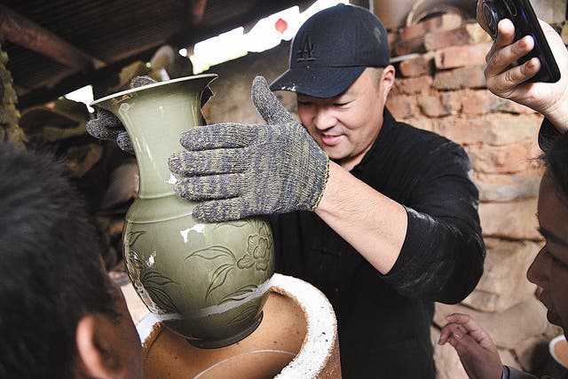 <p>A celadon vase is removed from a kiln in Longquan, Zhejiang province, in 2018 </p>